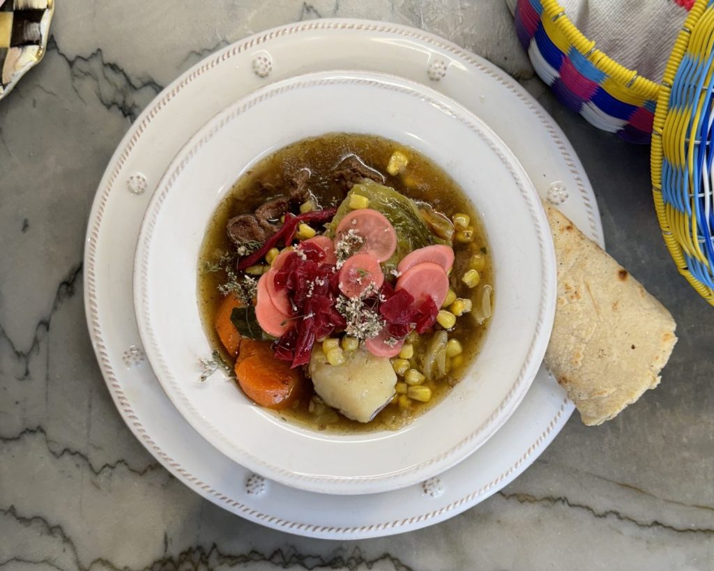 Mexican beef soup in a white bowl with corn tortilla