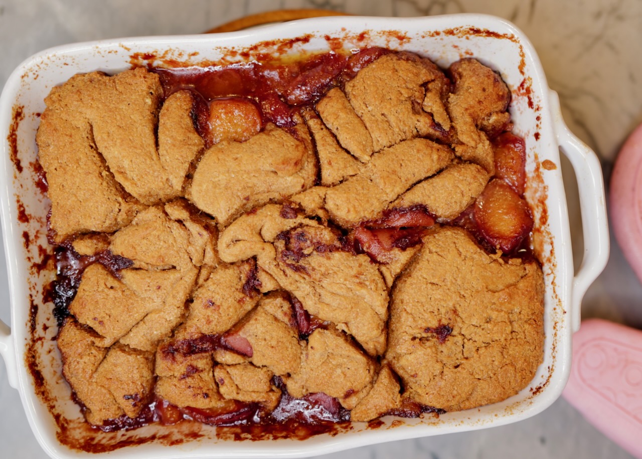 homemade peach cobbler in white baking dish