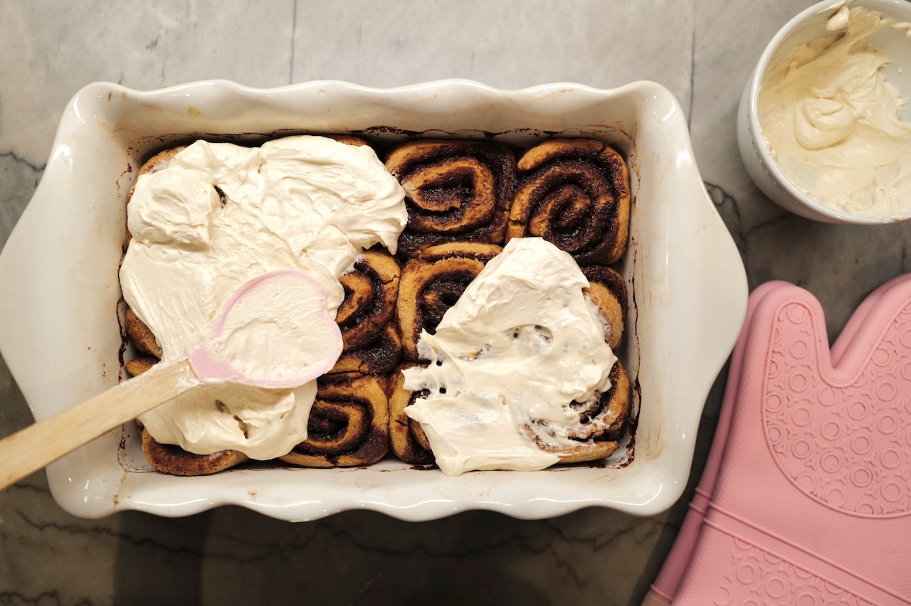 sourdough cinnamon rolls with cream cheese frosting in white baking dish