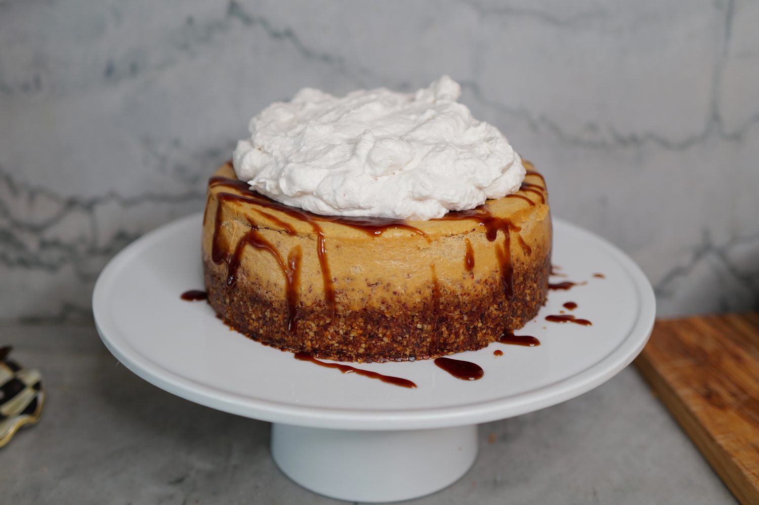 pumpkin cheesecake with caramel drizzle on cake stand